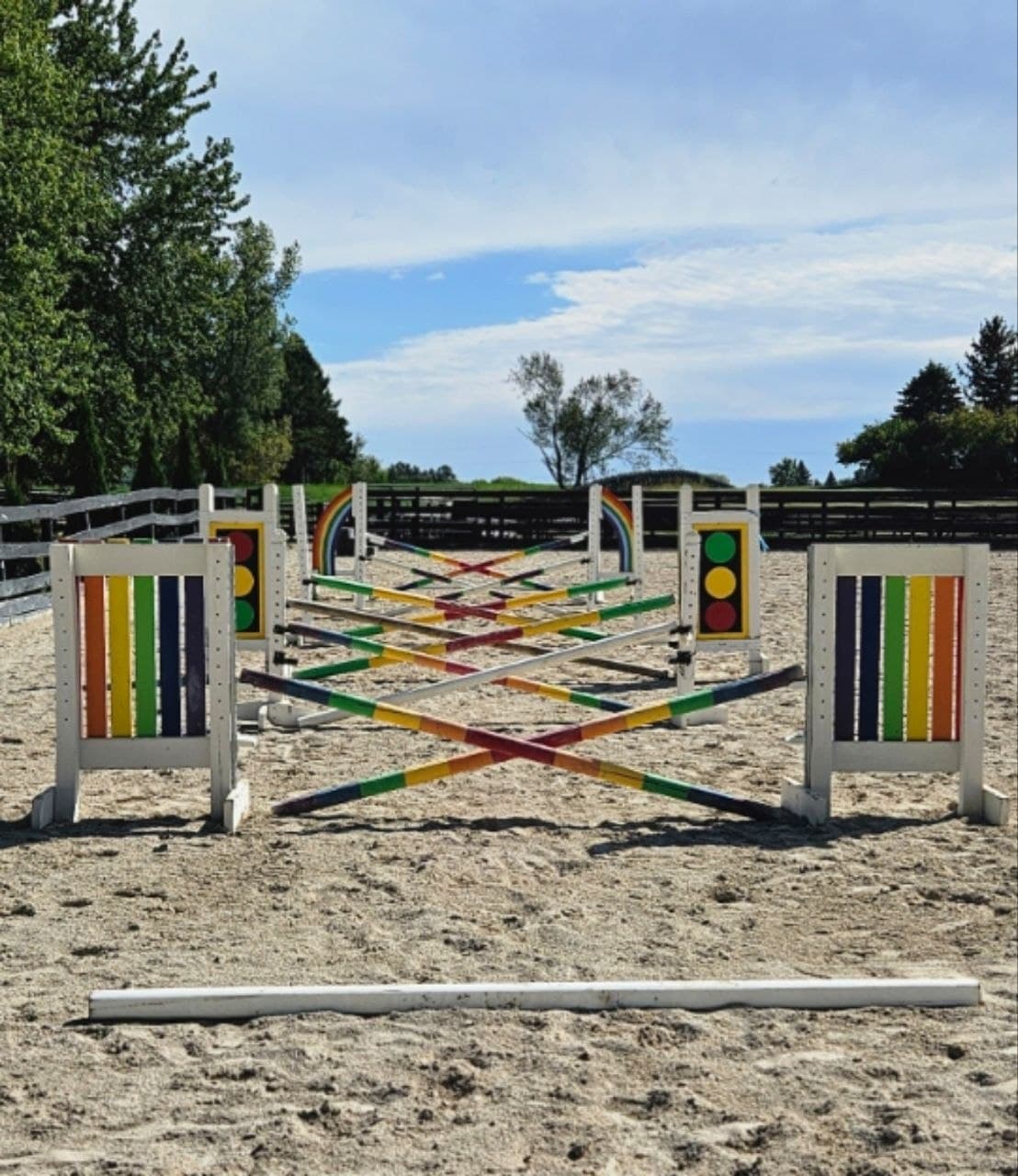 Rainbow-colored training jumps set in an outdoor arena